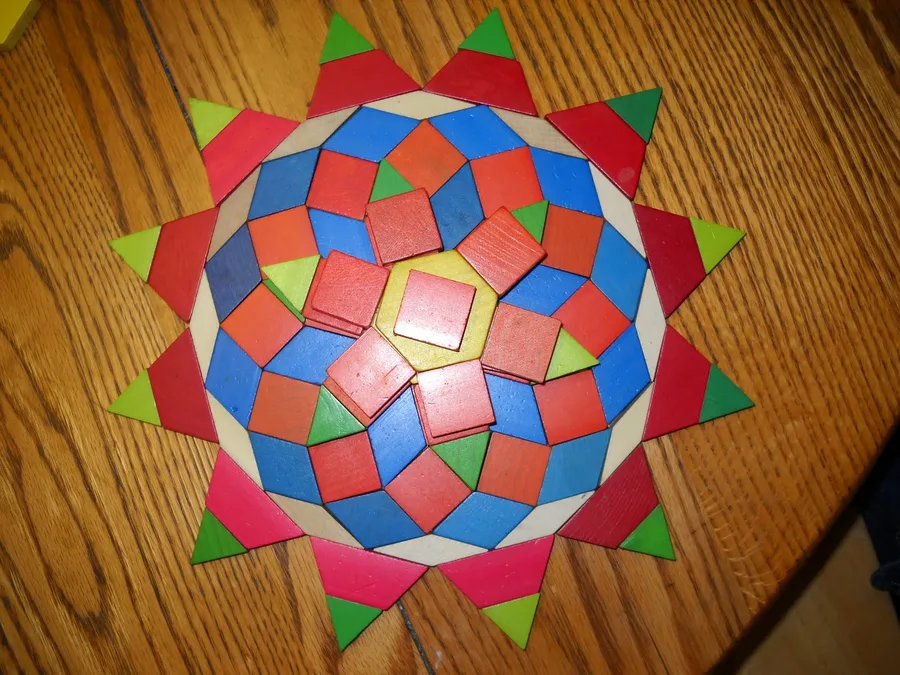A hand-cut paper tessellation in red, blue and green forming a star.